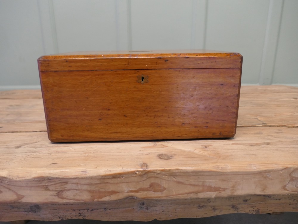 A rectangular warm brown Victorian oak presentation box featuring a hinged lid with a central brass monogrammed plaque and a keyhole on the front face. View III