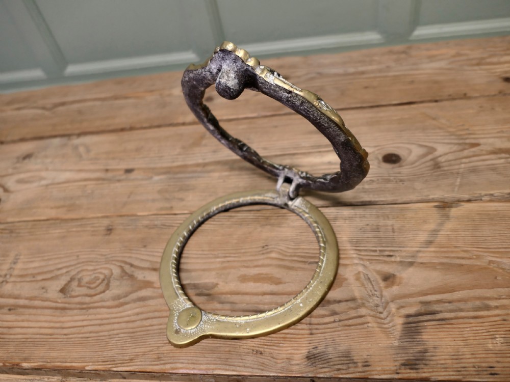 An aged cast brass ring door knocker featuring a floral rosette motif and a textured circular ring. View III
