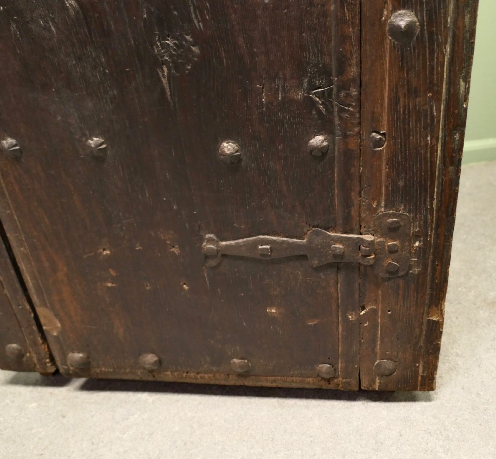 A narrow dark oak alcove cupboard featuring an arched top frame, iron studs, and hand-forged wrought iron hinges. View VIII