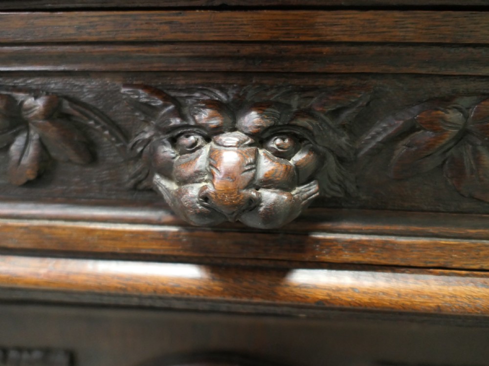 A dark brown carved oak French sideboard featuring two frieze drawers above twin cupboard doors with oval medallions depicting relief-carved game birds, flanked by barley twist columns. View VI