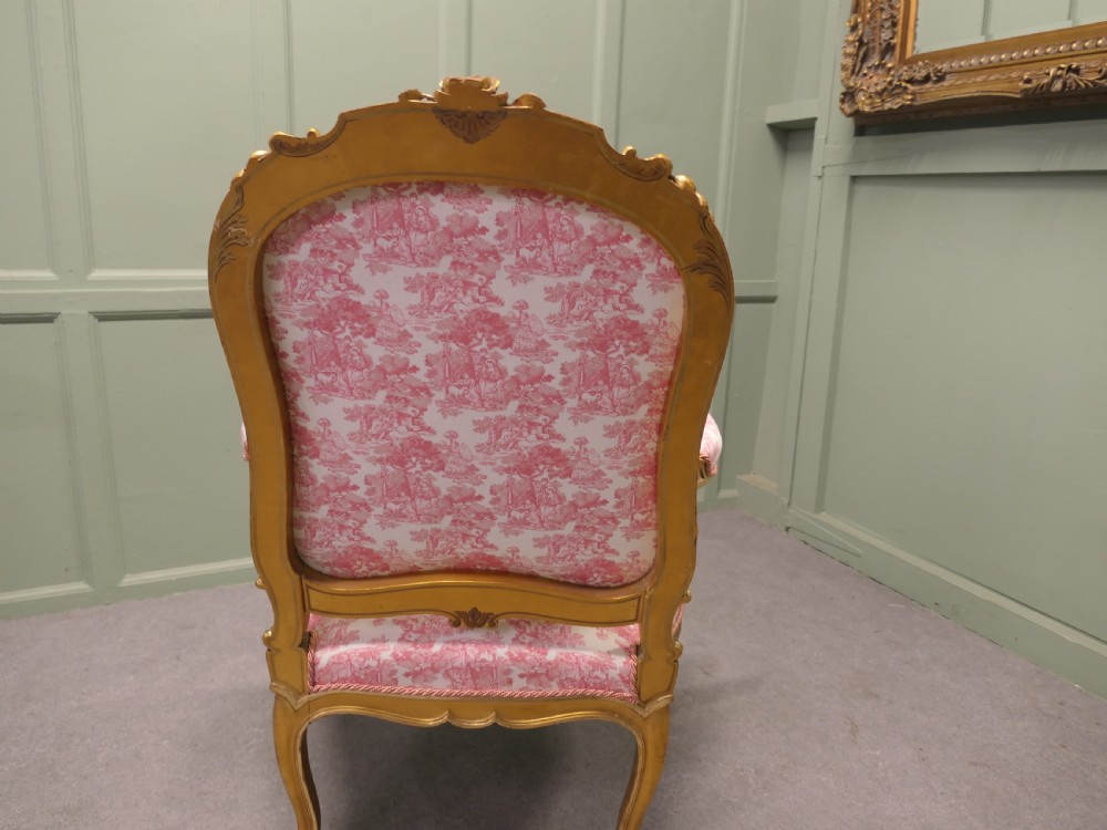 A pair of 19th-century French giltwood salon armchairs featuring carved floral frames and pink pattern fabric upholstery. View VI