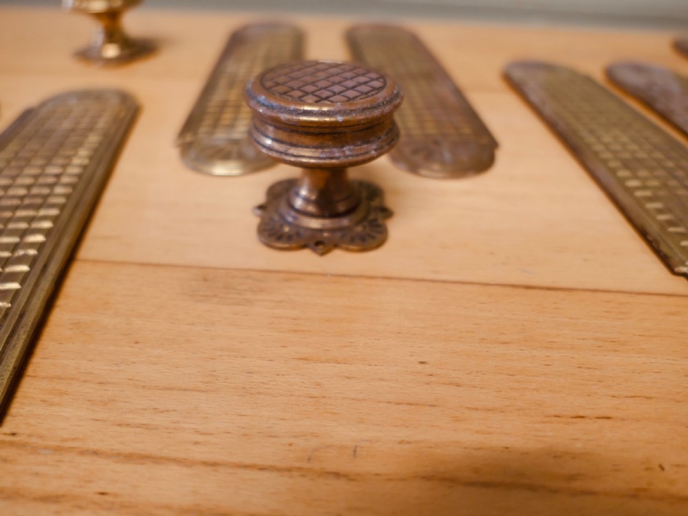 A set of brass Arts and Crafts finger plates and matching round door knobs featuring geometric lattice engraving and fan details. View III