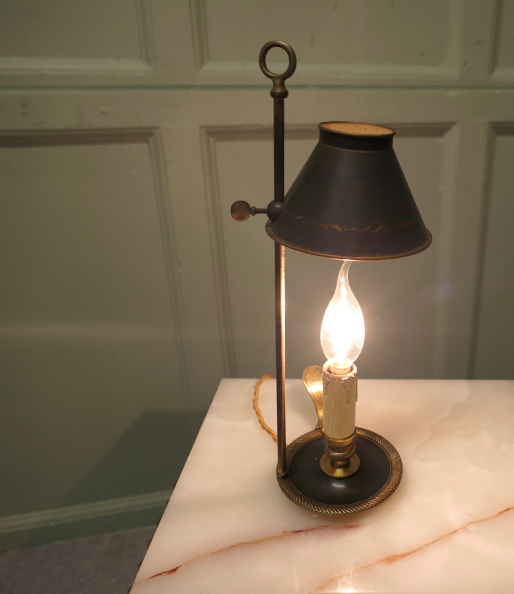An antique French toleware and brass candle lamp featuring a dark green shade with gilt detailing, set upon a brass central stem and dished base. View III