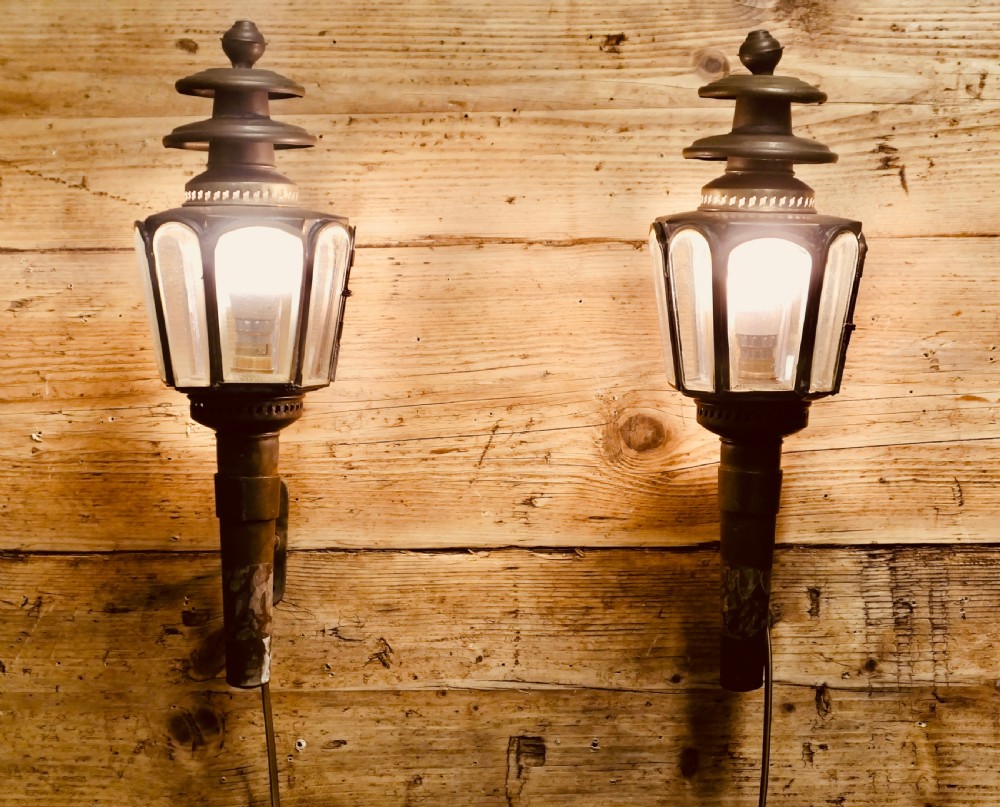 A pair of wall-mounted French brass carriage lanterns featuring tiered chimney tops and glazed glass panels. View V