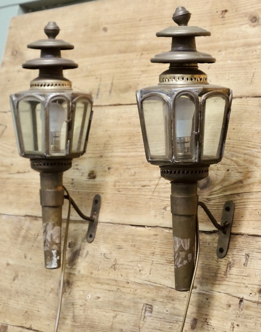 A pair of wall-mounted French brass carriage lanterns featuring tiered chimney tops and glazed glass panels. View VI
