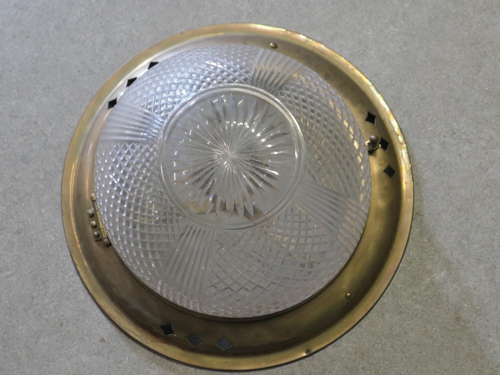 An Art Deco flush mount ceiling light featuring a hemispherical cut glass shade with geometric diamond patterns set into a dark metal collar with diamond-shaped perforations. View II