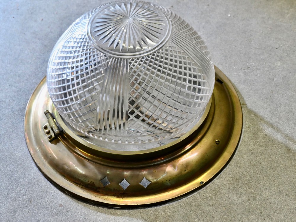 An Art Deco flush mount ceiling light featuring a hemispherical cut glass shade with geometric diamond patterns set into a dark metal collar with diamond-shaped perforations. View IV