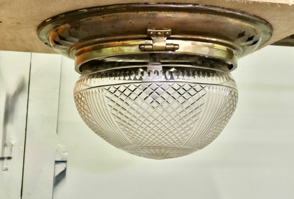 An Art Deco flush mount ceiling light featuring a hemispherical cut glass shade with geometric diamond patterns set into a dark metal collar with diamond-shaped perforations. View VI