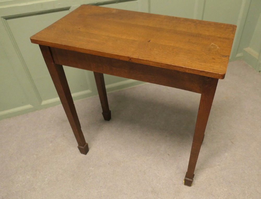 A rectangular Arts and Crafts solid oak side table featuring straight tapered legs ending in block feet. View II