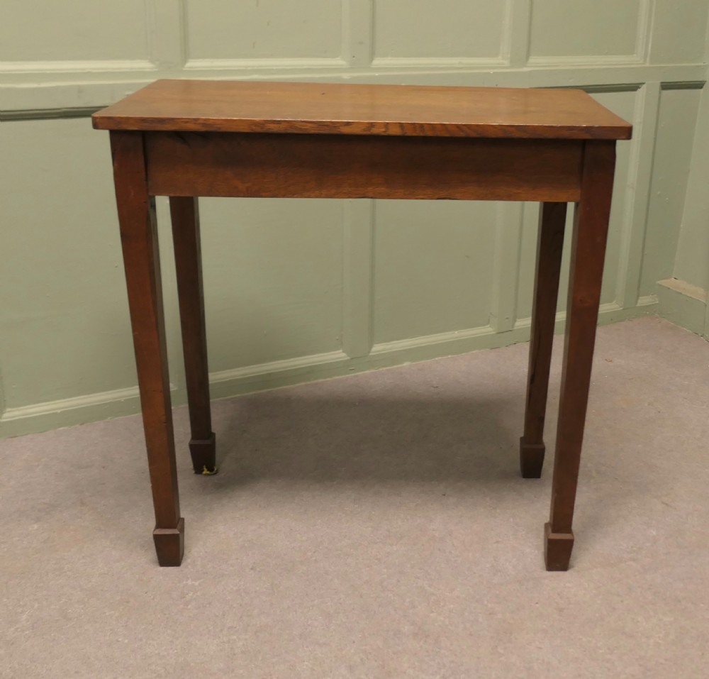 A rectangular Arts and Crafts solid oak side table featuring straight tapered legs ending in block feet. View IV