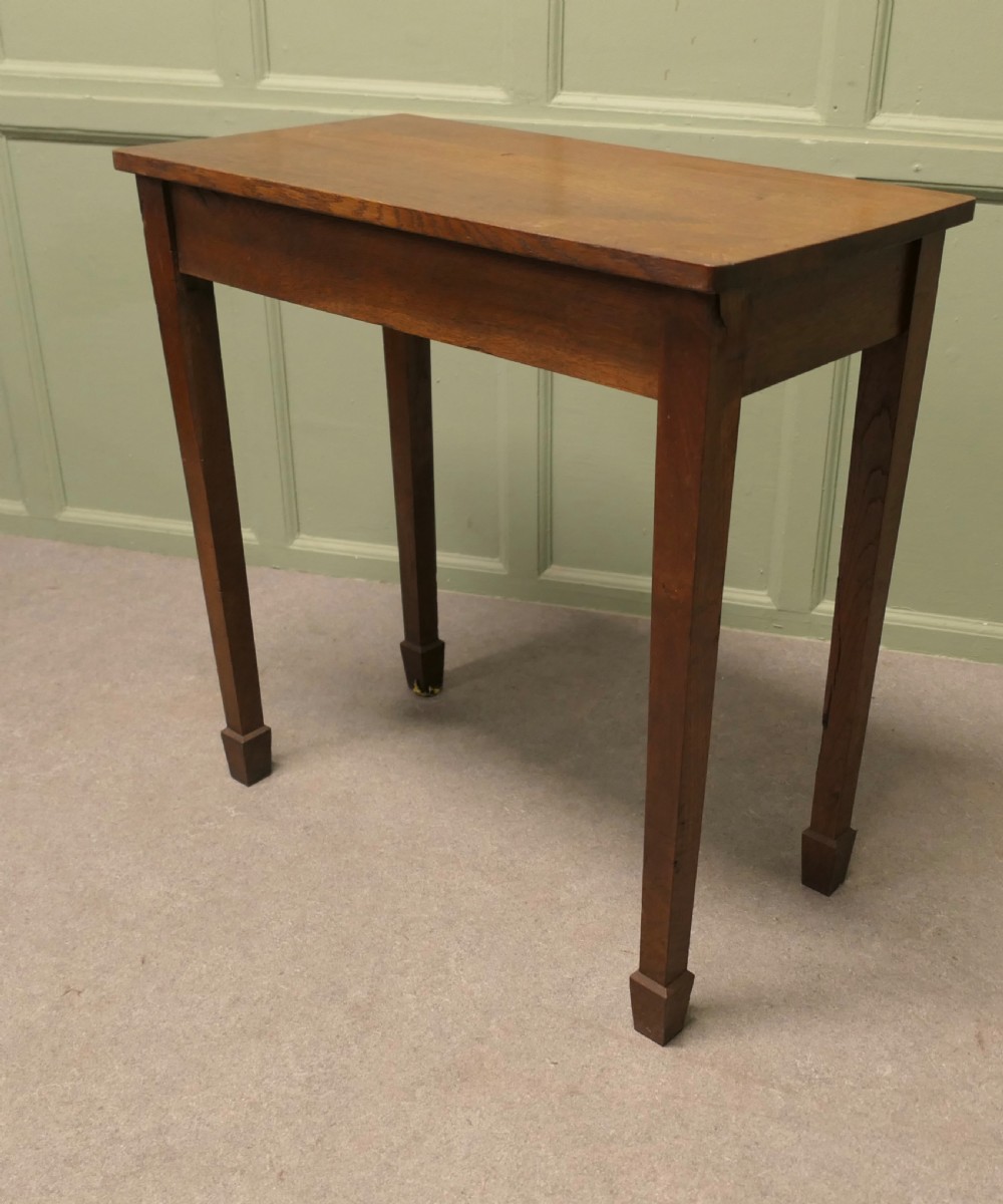 A rectangular Arts and Crafts solid oak side table featuring straight tapered legs ending in block feet. View V