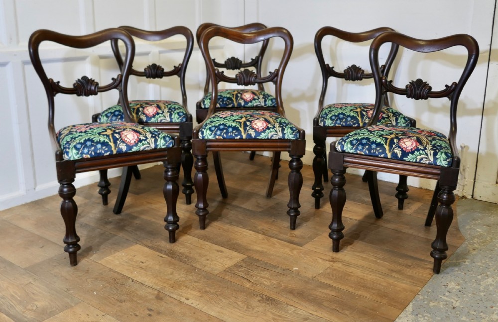 A set of six Victorian mahogany balloon-back dining chairs with carved mid-rails and blue floral patterned velvet seats. View III