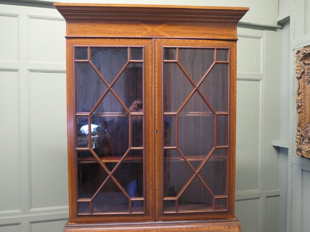 An Edwardian mahogany bureau bookcase featuring an upper cabinet with astragal glazed doors, a sloping fall-front writing surface with marquetry inlay, and four lower drawers with brass handles. View IV