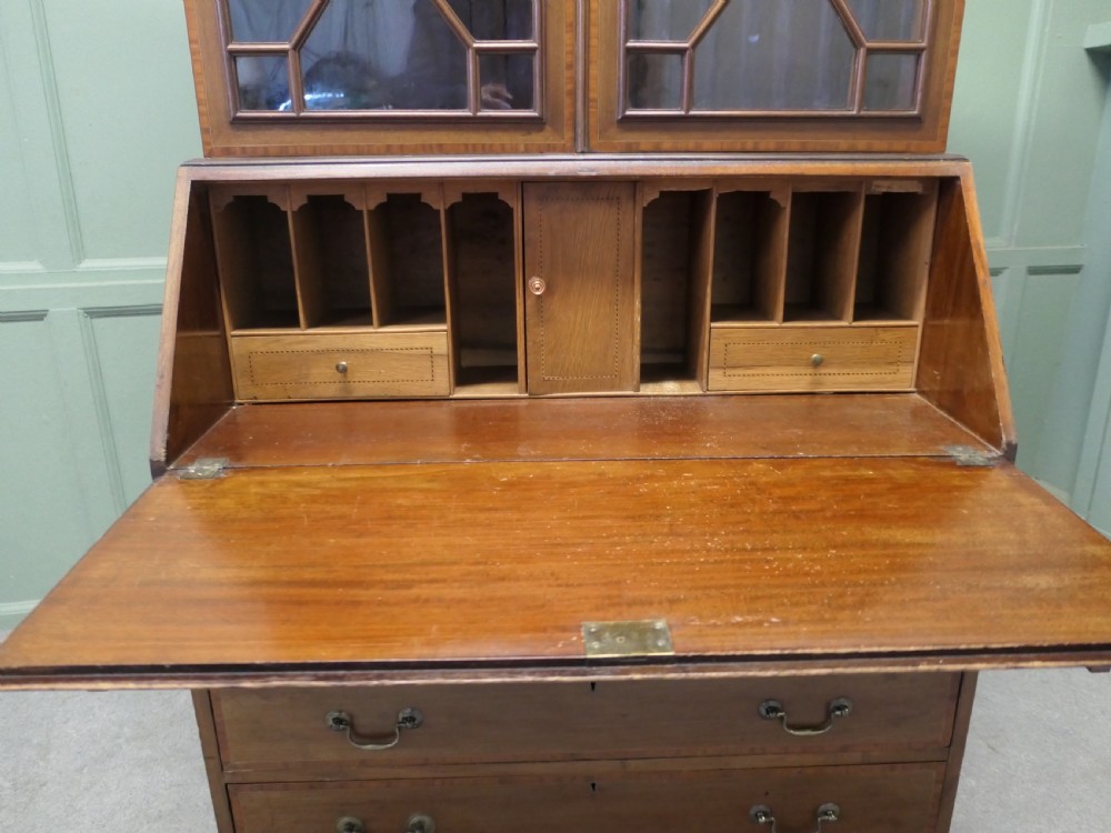 An Edwardian mahogany bureau bookcase featuring an upper cabinet with astragal glazed doors, a sloping fall-front writing surface with marquetry inlay, and four lower drawers with brass handles. View VI