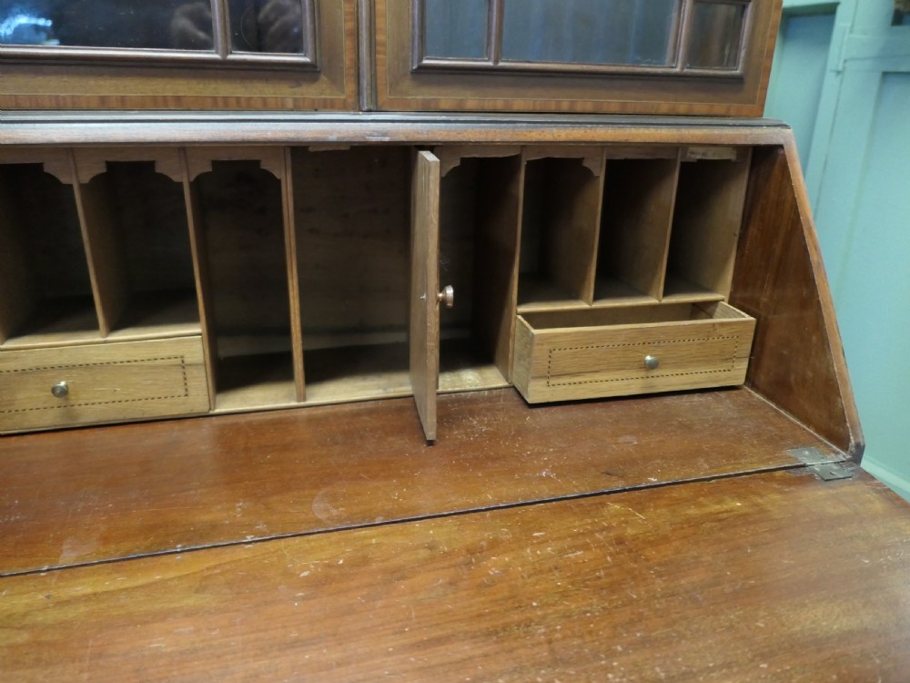 An Edwardian mahogany bureau bookcase featuring an upper cabinet with astragal glazed doors, a sloping fall-front writing surface with marquetry inlay, and four lower drawers with brass handles. View VII