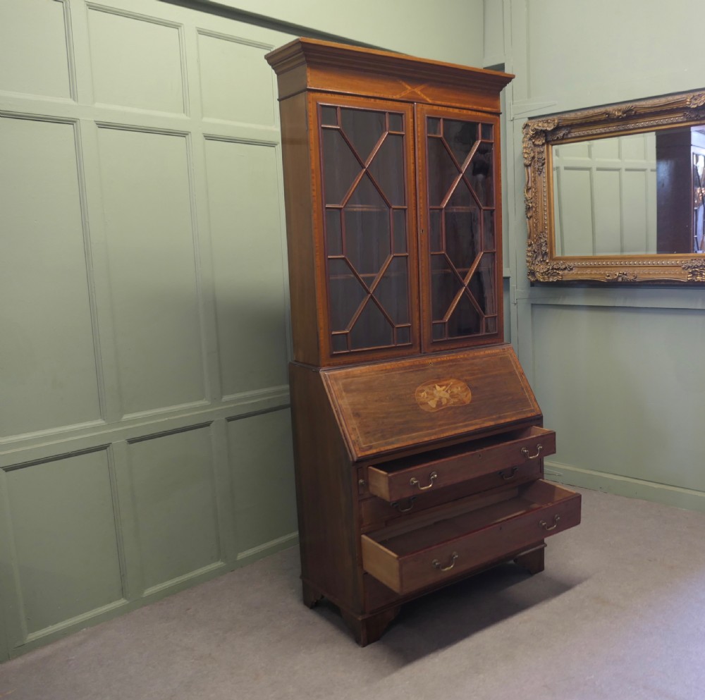 An Edwardian mahogany bureau bookcase featuring an upper cabinet with astragal glazed doors, a sloping fall-front writing surface with marquetry inlay, and four lower drawers with brass handles. View VIII