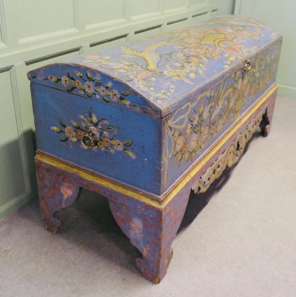 A large blue hand-painted wooden marriage chest decorated with floral motifs, birds, and an openwork scroll-carved base apron. View II