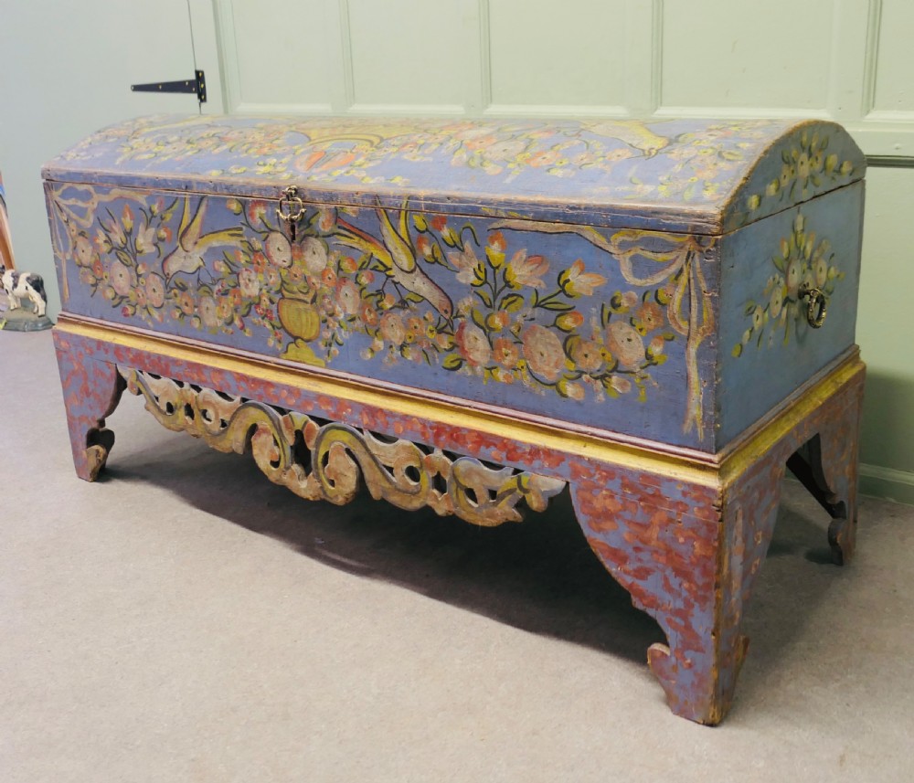 A large blue hand-painted wooden marriage chest decorated with floral motifs, birds, and an openwork scroll-carved base apron. View IV