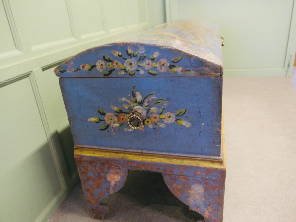 A large blue hand-painted wooden marriage chest decorated with floral motifs, birds, and an openwork scroll-carved base apron. View V