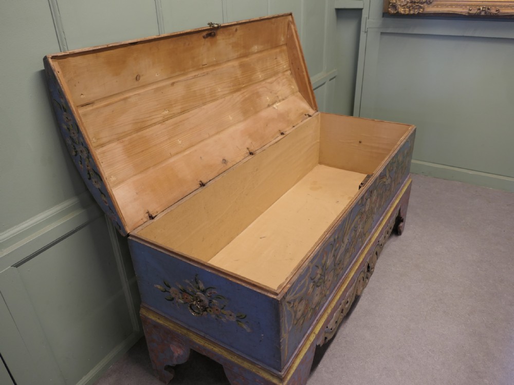 A large blue hand-painted wooden marriage chest decorated with floral motifs, birds, and an openwork scroll-carved base apron. View VI