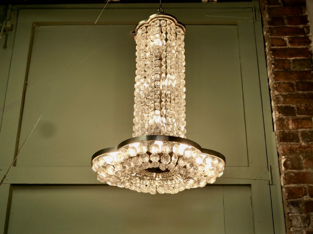 A large Art Deco tiered ceiling chandelier featuring cylindrical and cascading tiers of faceted clear crystal beads supported by a polished metal frame. View III