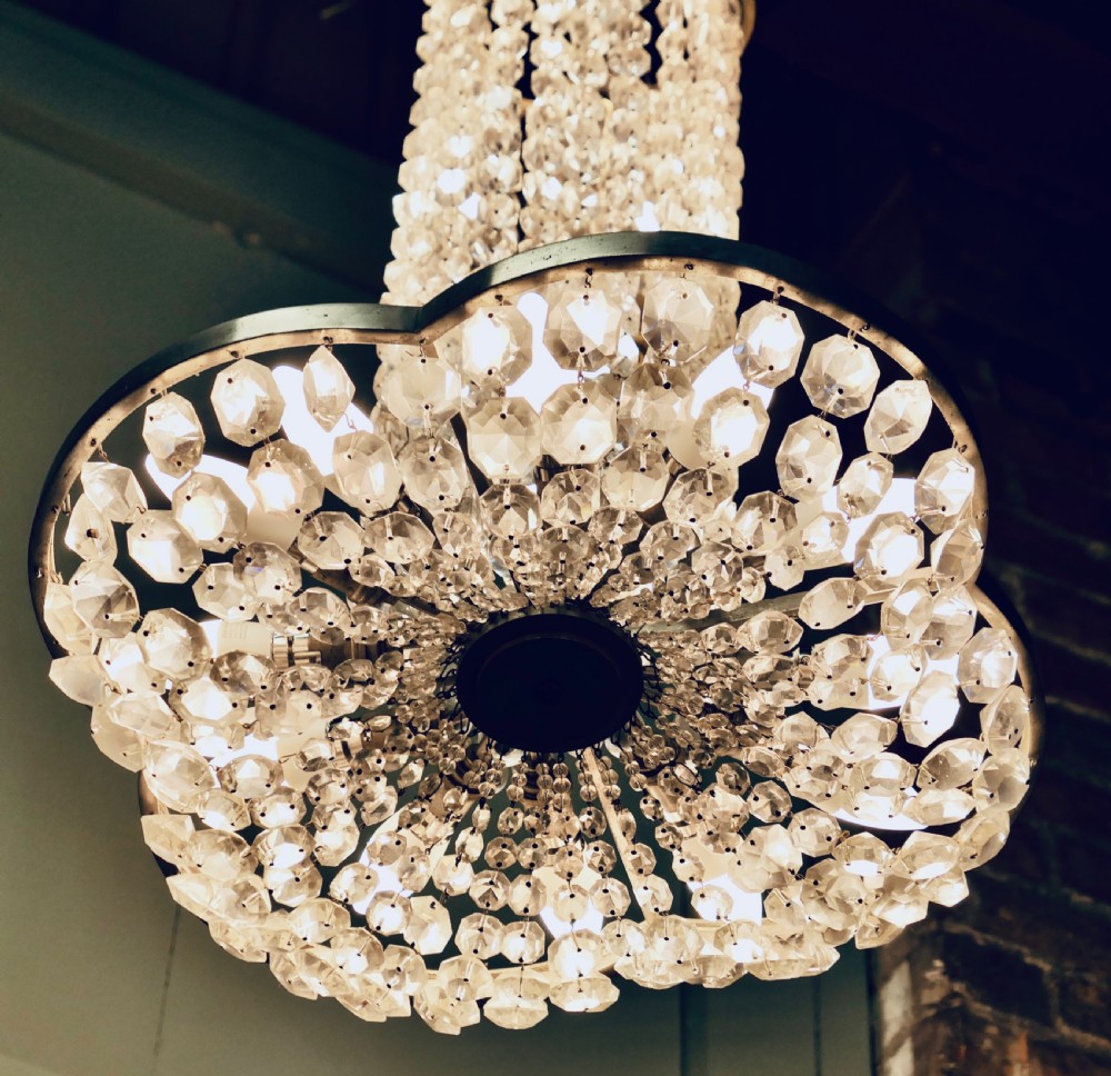 A large Art Deco tiered ceiling chandelier featuring cylindrical and cascading tiers of faceted clear crystal beads supported by a polished metal frame. View V