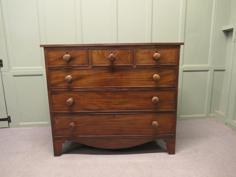 A late 18th-century Georgian mahogany chest of drawers featuring three small top drawers above three full-width drawers with turned wooden handles and a curved lower apron.