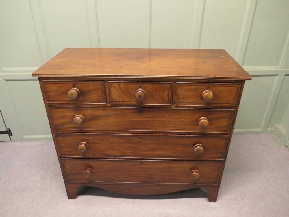 A late 18th-century Georgian mahogany chest of drawers featuring three small top drawers above three full-width drawers with turned wooden handles and a curved lower apron. View II