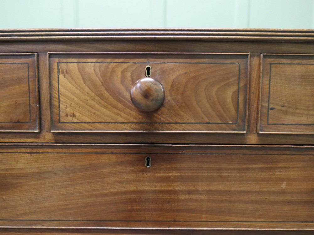 A late 18th-century Georgian mahogany chest of drawers featuring three small top drawers above three full-width drawers with turned wooden handles and a curved lower apron. View IV