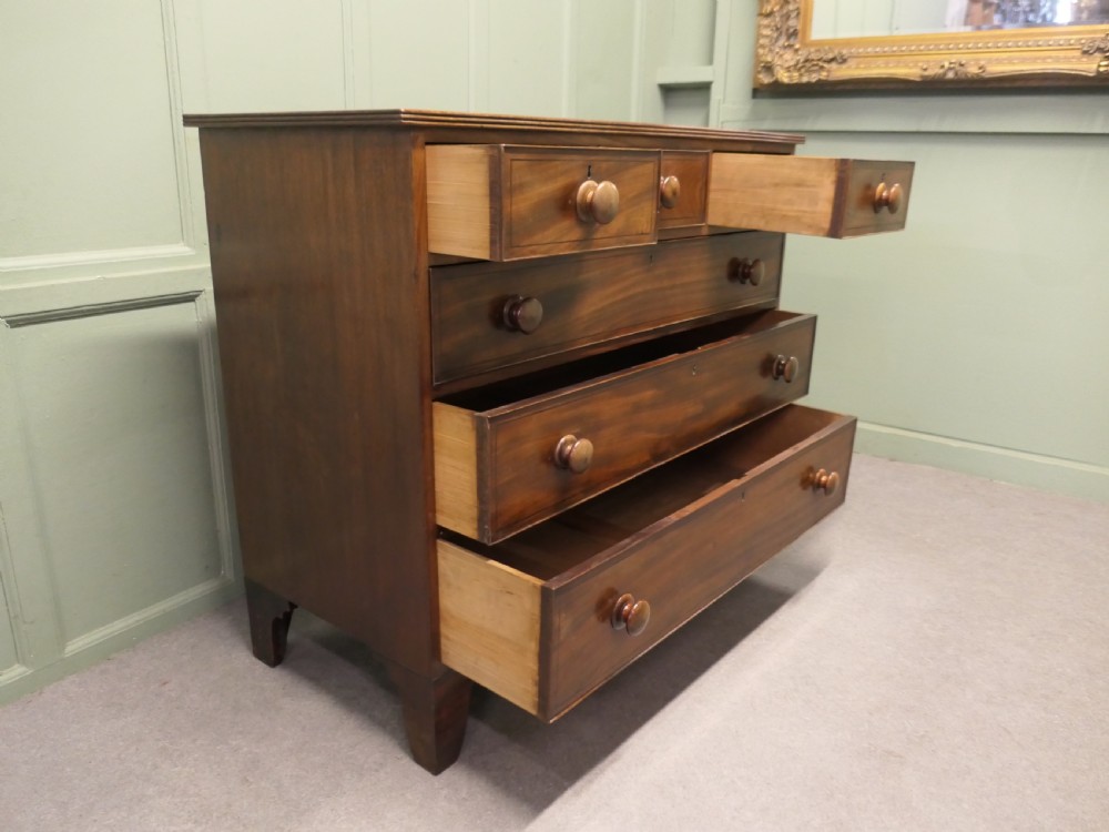 A late 18th-century Georgian mahogany chest of drawers featuring three small top drawers above three full-width drawers with turned wooden handles and a curved lower apron. View V