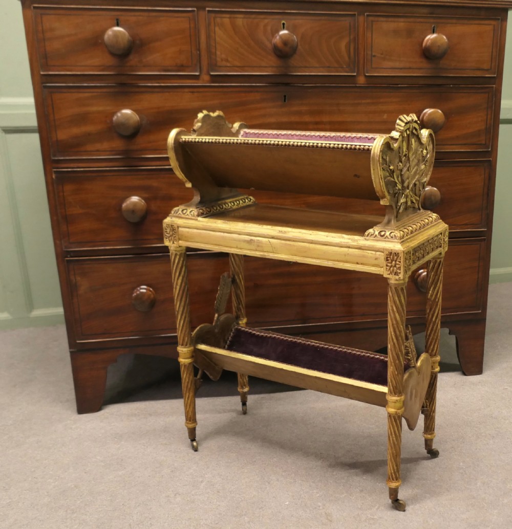 A gilded wooden two-tier book trough featuring spiral legs, carved cresting, and purple velvet lining. View III