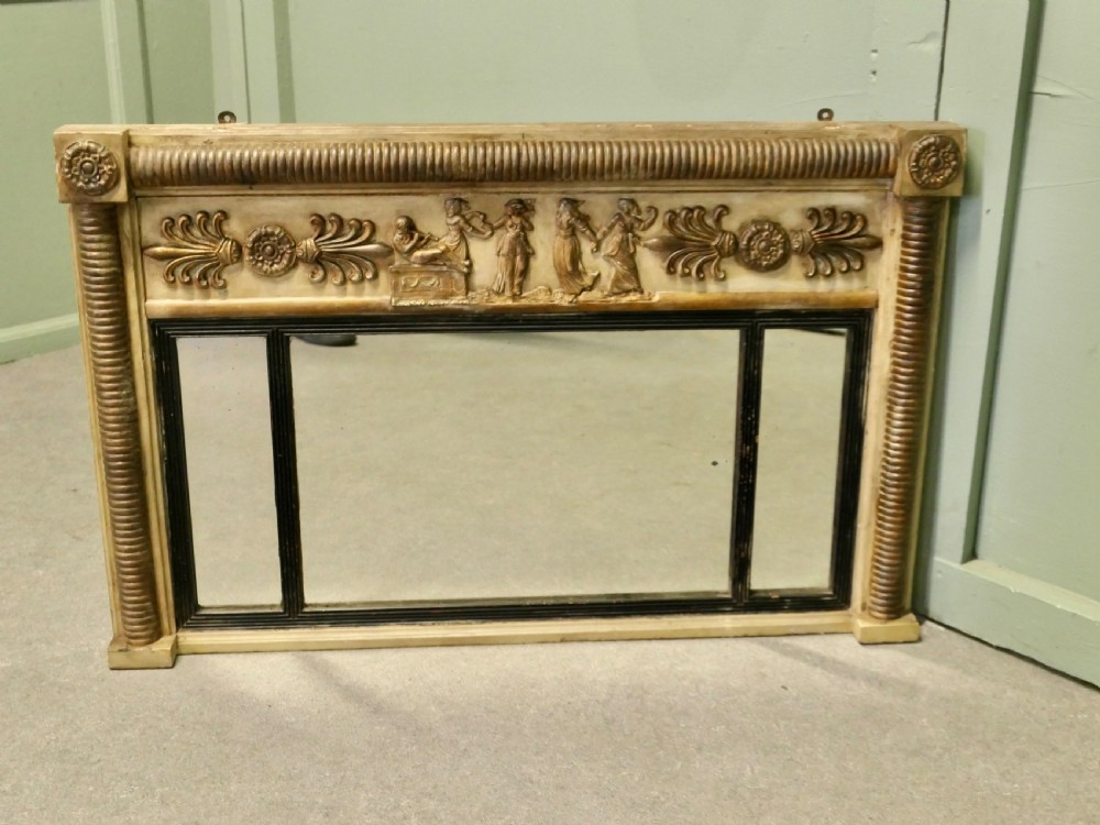 A horizontal Regency style triple plate overmantel mirror with a classical relief frieze, reeded side columns, and corner rosettes.