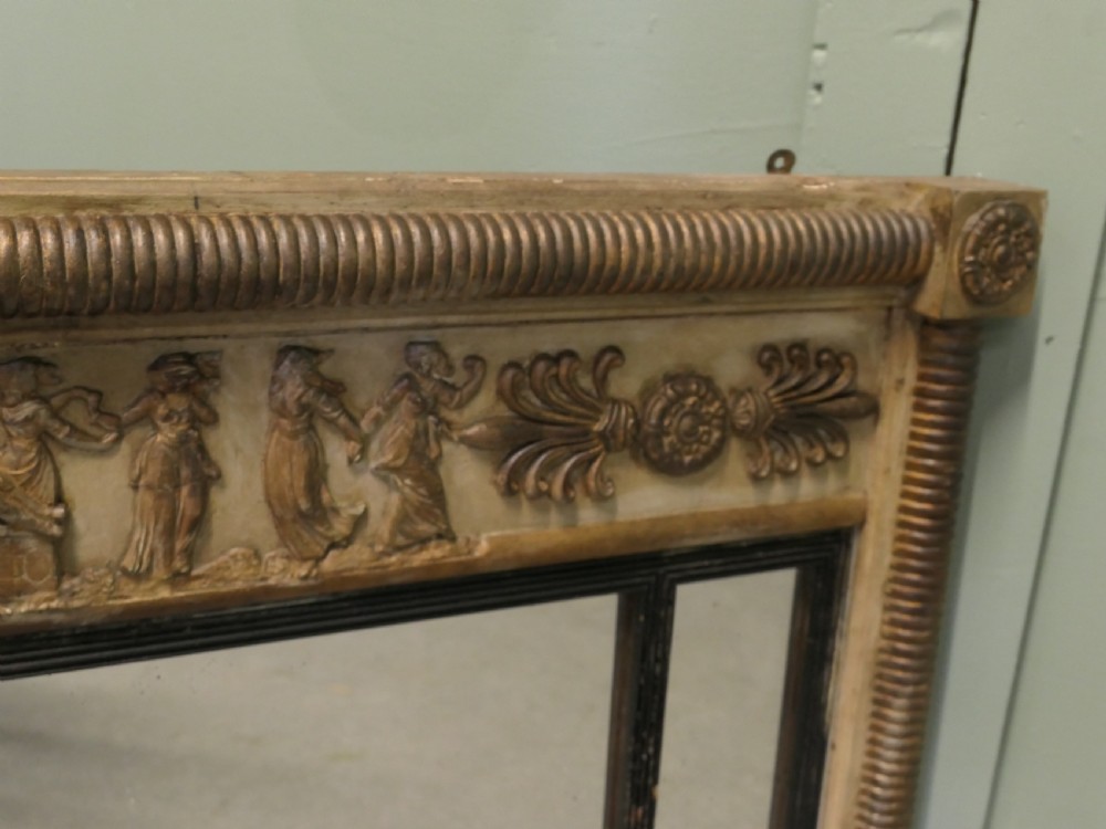 A horizontal Regency style triple plate overmantel mirror with a classical relief frieze, reeded side columns, and corner rosettes. View III