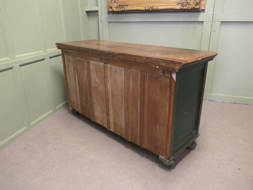 A Victorian green painted wooden dresser base with two drawers, two lower cabinet doors featuring hand-painted grape motifs, and a natural wood top surface. View VII