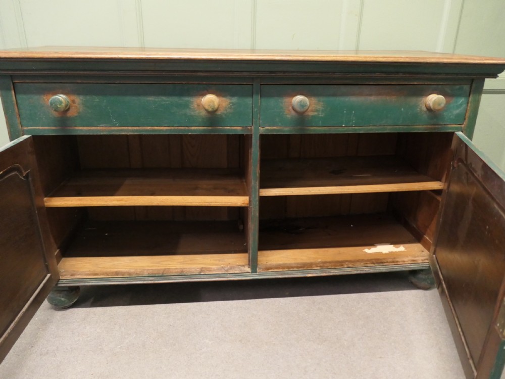 A Victorian green painted wooden dresser base with two drawers, two lower cabinet doors featuring hand-painted grape motifs, and a natural wood top surface. View VIII