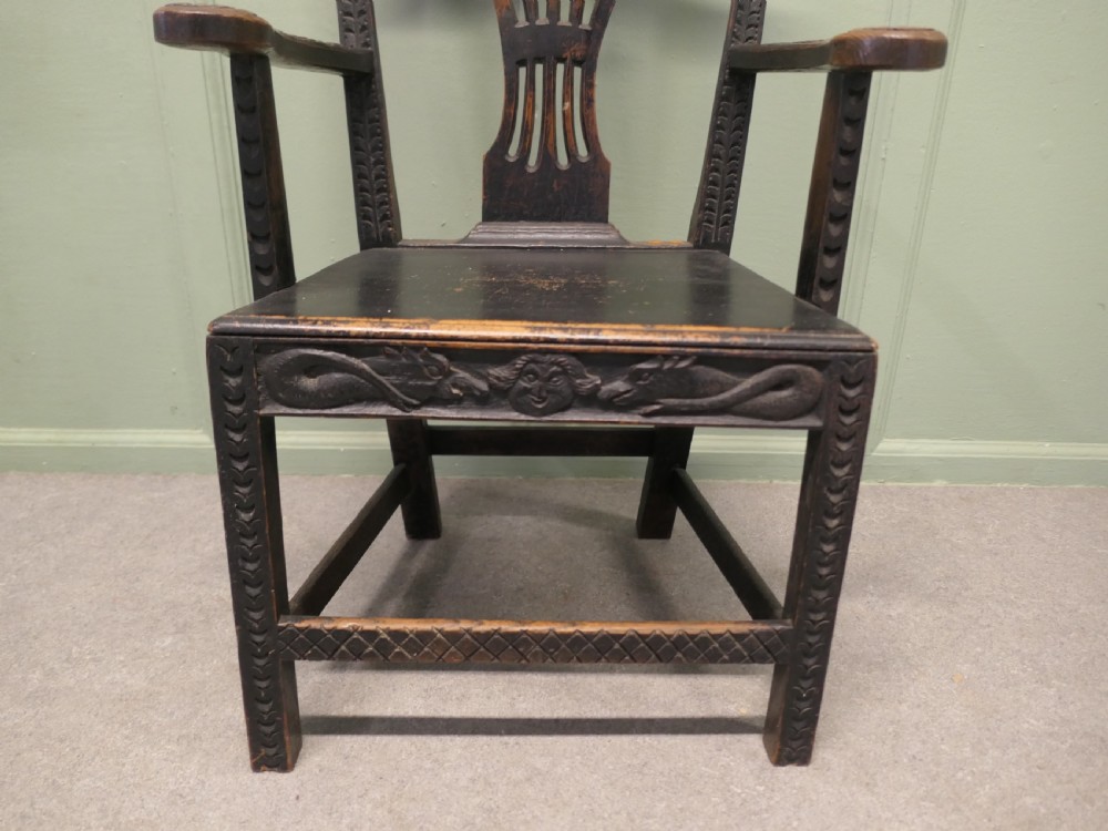 A dark hand-carved Chippendale style armchair featuring a pierced back splat, carved armrests, geometric leg carving, and a relief-carved lower seat apron. View III