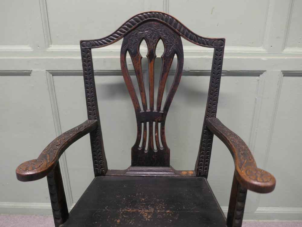 A dark hand-carved Chippendale style armchair featuring a pierced back splat, carved armrests, geometric leg carving, and a relief-carved lower seat apron. View IV