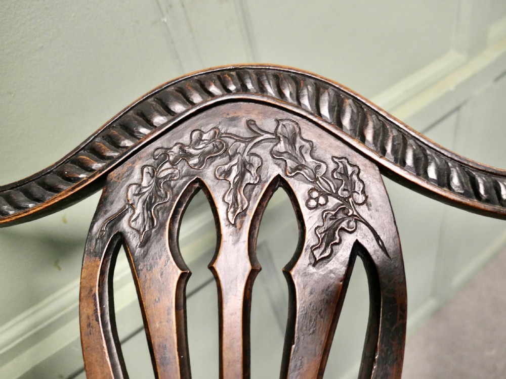 A dark hand-carved Chippendale style armchair featuring a pierced back splat, carved armrests, geometric leg carving, and a relief-carved lower seat apron. View VI