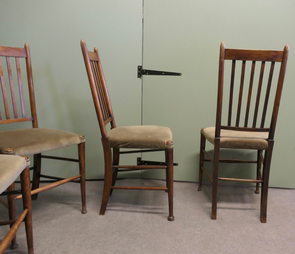 Set of five Arts and Crafts golden oak dining chairs featuring vertical slat backrests and fabric upholstered seats. View II