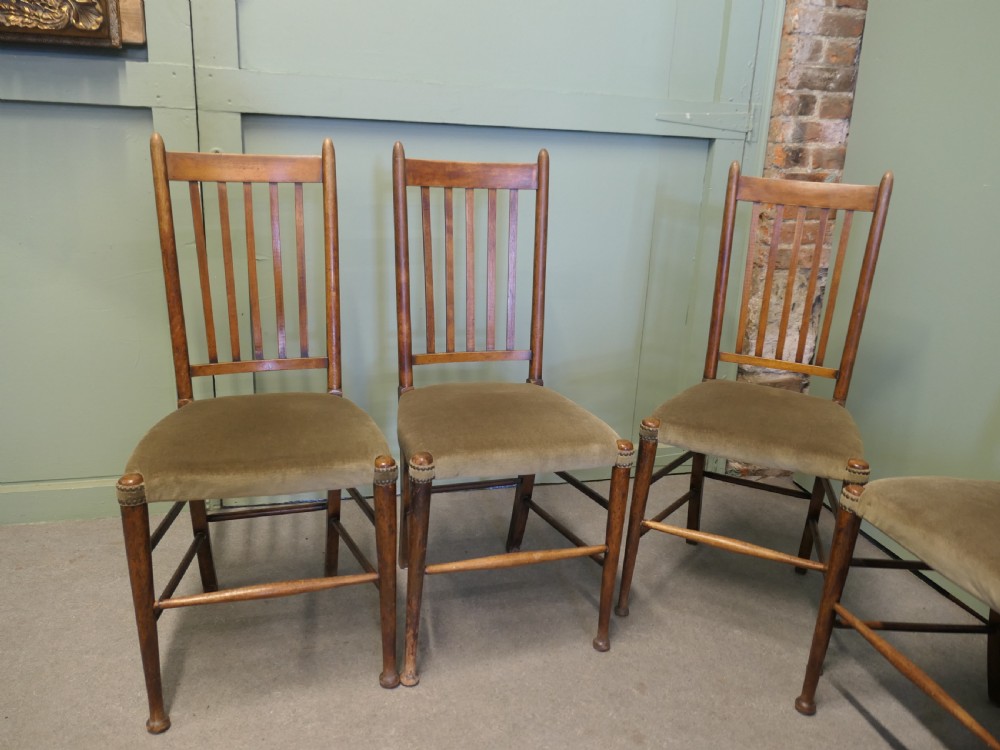 Set of five Arts and Crafts golden oak dining chairs featuring vertical slat backrests and fabric upholstered seats. View III