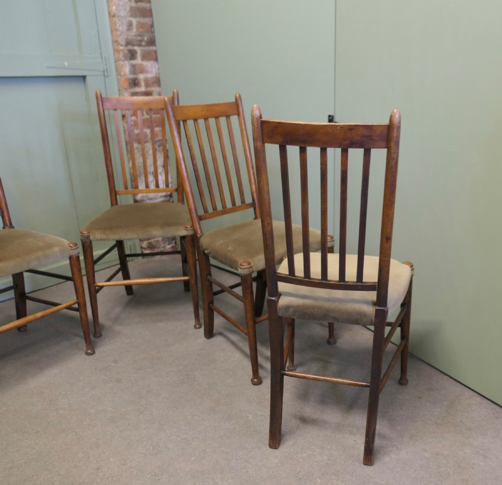 Set of five Arts and Crafts golden oak dining chairs featuring vertical slat backrests and fabric upholstered seats. View V