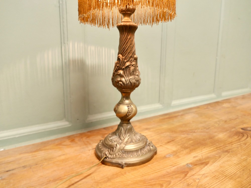 A French Arts and Crafts brass reading lamp featuring a dome shade adorned with floral repousse work, blue glass cabochons, and beaded fringe on a sculpted stem. View III
