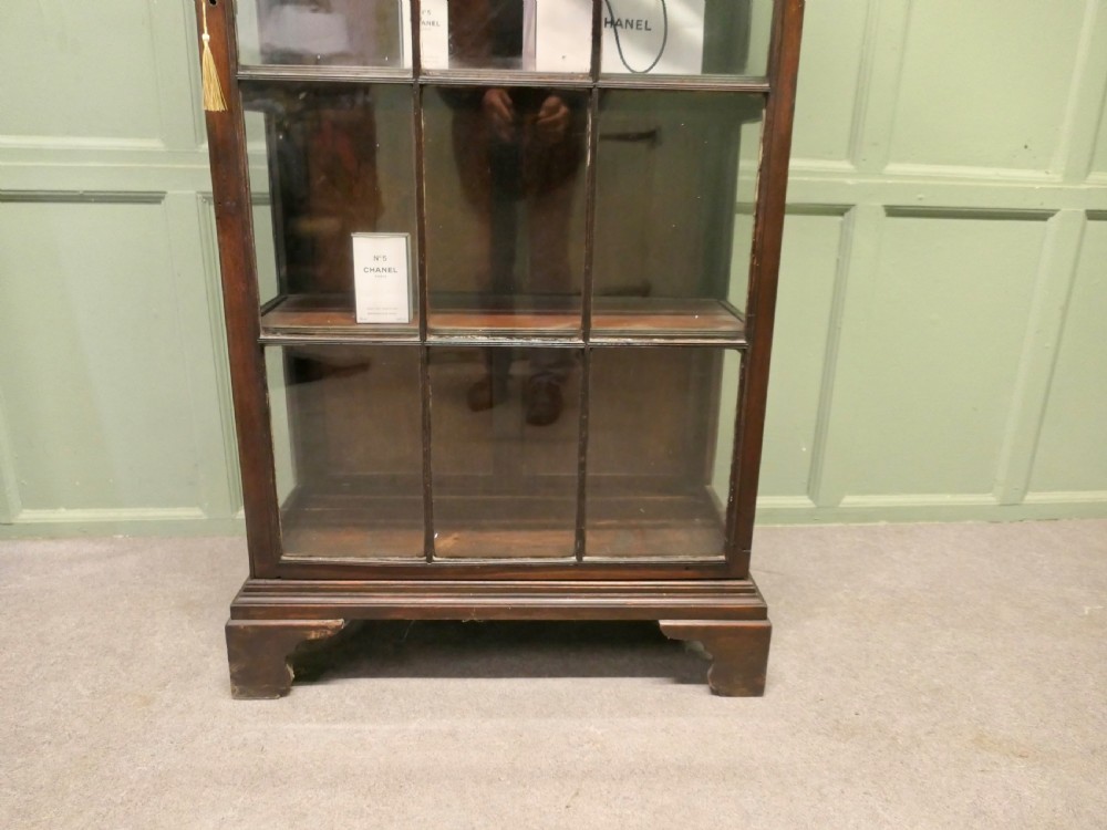 A tall early 19th-century dark mahogany bookcase with Gothic arched glazed doors and bracket feet. View V