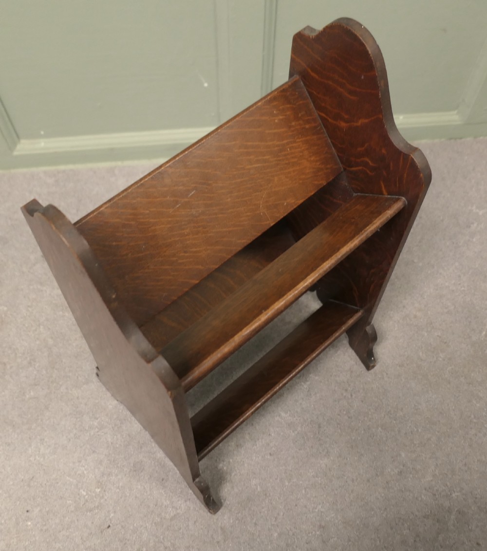 A solid oak Arts and Crafts two-tier book trough featuring sloped shelves and shaped side panels. View IV
