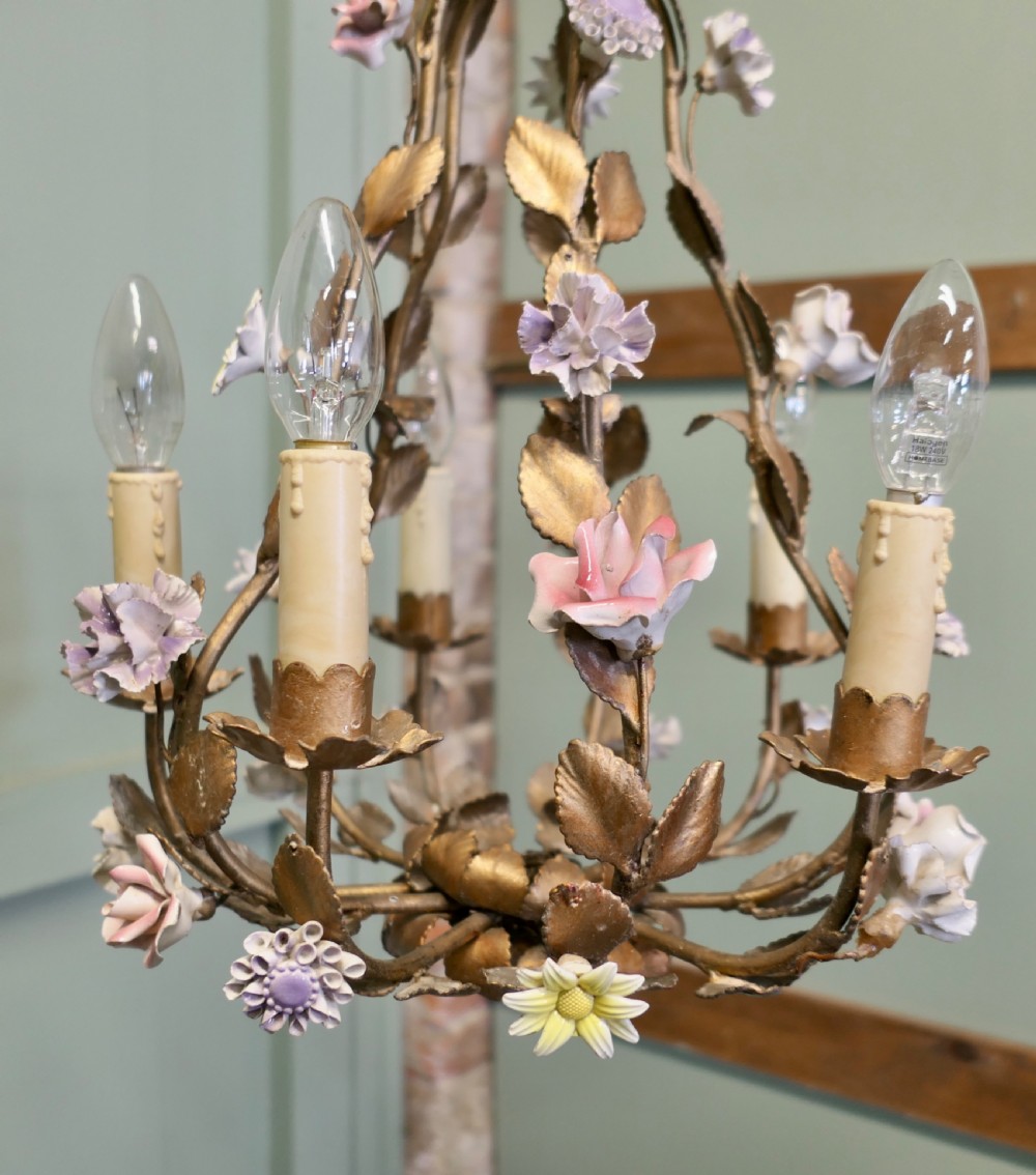 A French gilt toleware six-branch chandelier featuring metal leaf foliage and purple ceramic flowers. View II