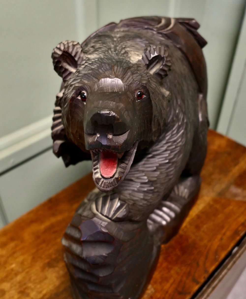 A hand-carved dark linden wood bear sculpture depicting a standing roaring bear holding a fish. View III