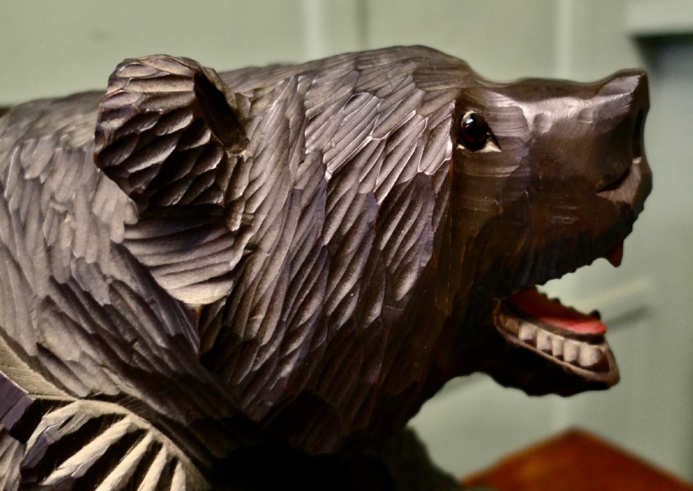 A hand-carved dark linden wood bear sculpture depicting a standing roaring bear holding a fish. View IV