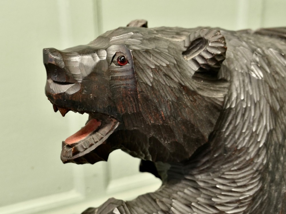 A hand-carved dark linden wood bear sculpture depicting a standing roaring bear holding a fish. View VI