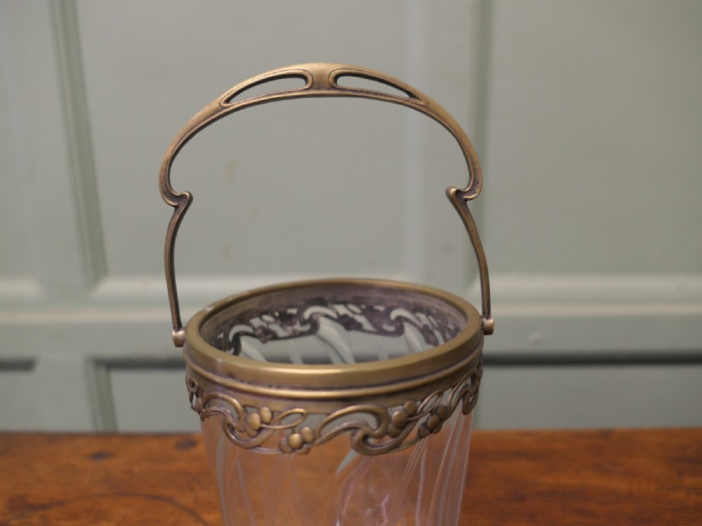 A small French Art Nouveau clear glass personal ice bucket featuring spiral fluted sides and an ornate brass collar with a swing handle. View II