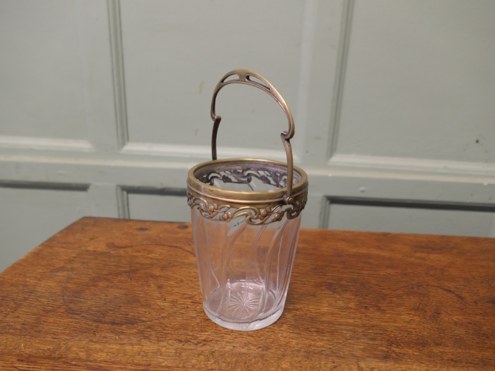 A small French Art Nouveau clear glass personal ice bucket featuring spiral fluted sides and an ornate brass collar with a swing handle. View III